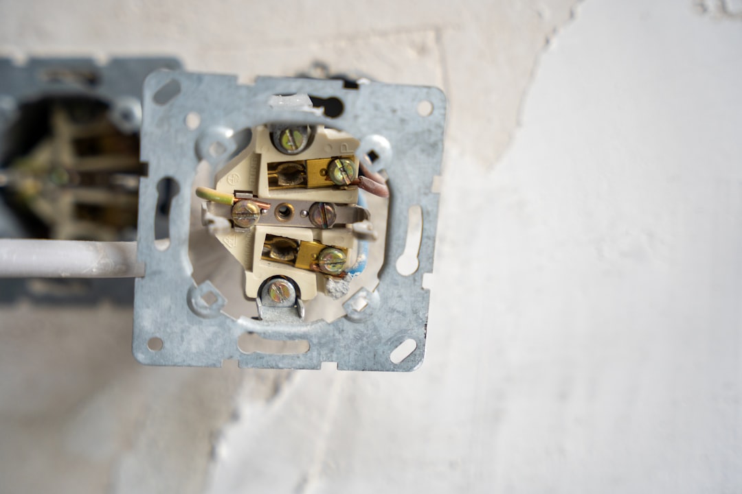 Electrical outlet disassembled, revealing the wiring