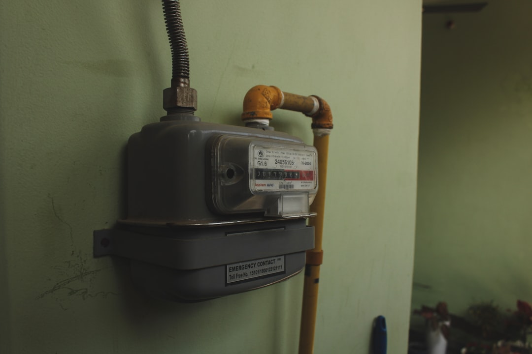 A gas meter mounted on a pale green wall