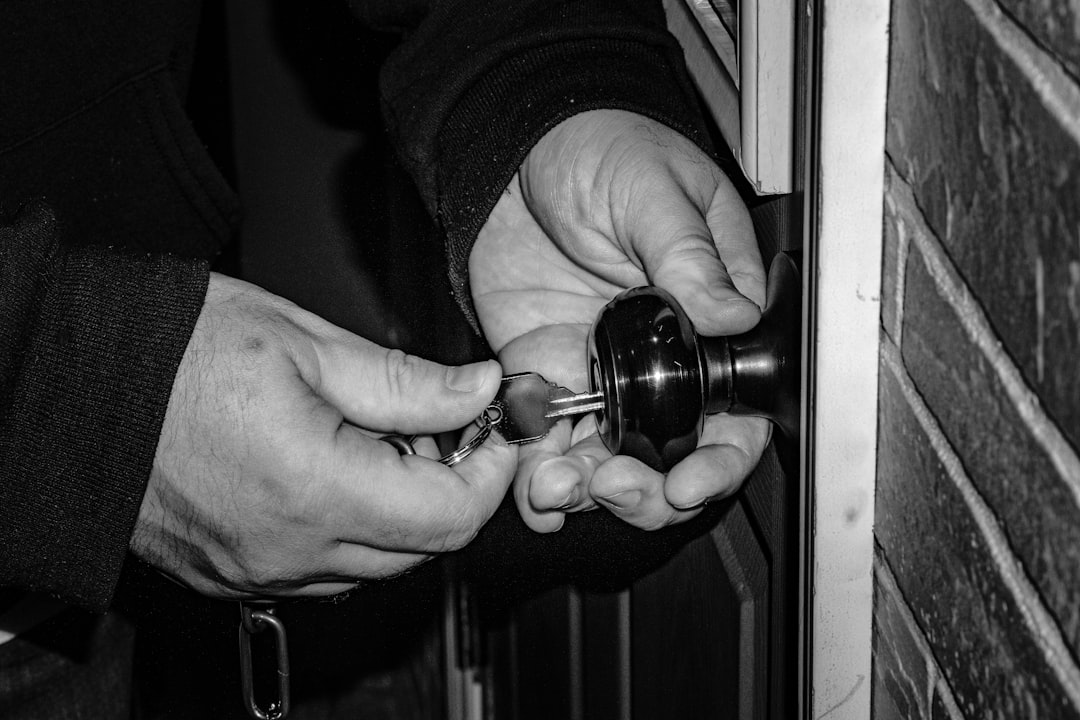 person holding black steel door knob